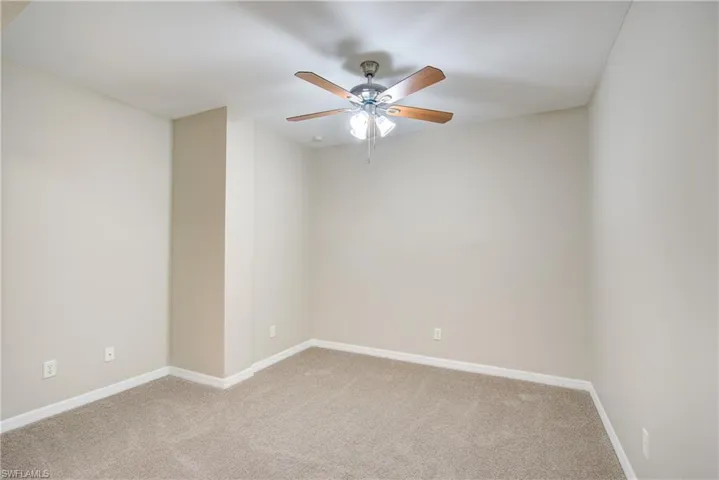 Carpeted spare room with ceiling fan