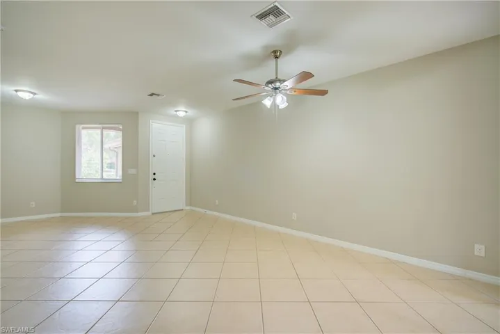 Unfurnished room with ceiling fan and light tile patterned flooring