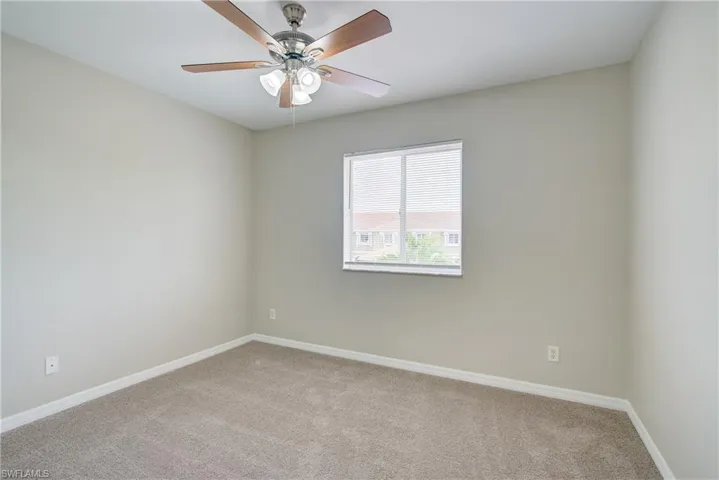 Carpeted empty room with ceiling fan