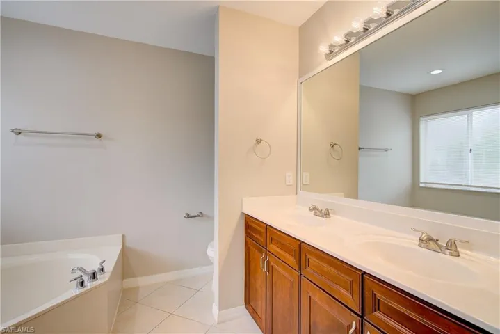 Bathroom featuring tile patterned floors, a bathtub, vanity, and toilet