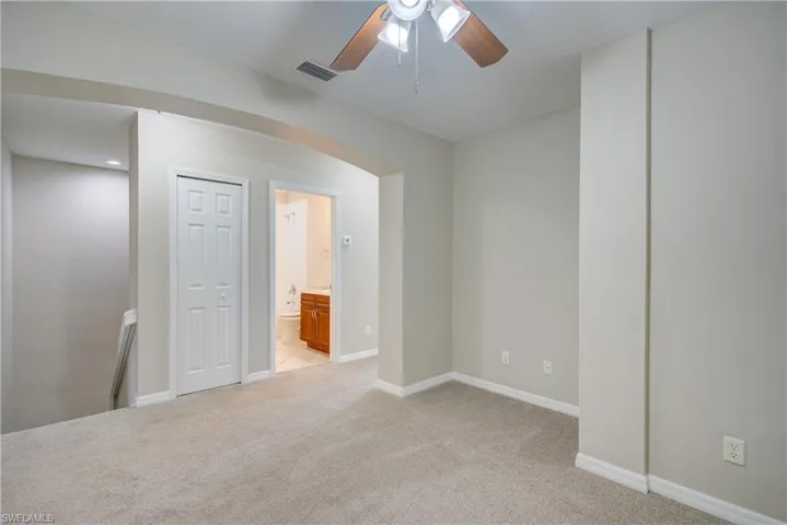 Unfurnished room featuring light carpet and ceiling fan