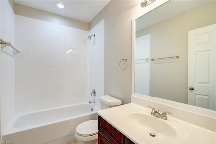 Full bathroom with toilet, vanity, and tiled shower / bath