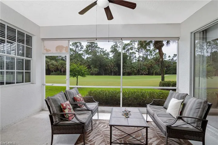 Sunroom / solarium featuring view of scattered trees