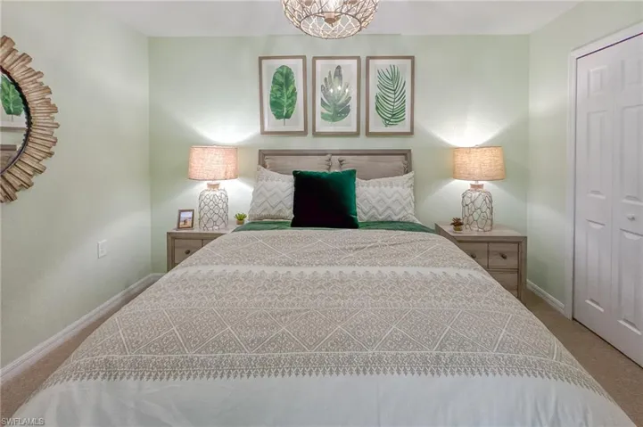 Carpeted bedroom featuring a closet and a chandelier