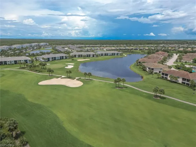 Aerial perspective of suburban area featuring a large body of water and a golf course