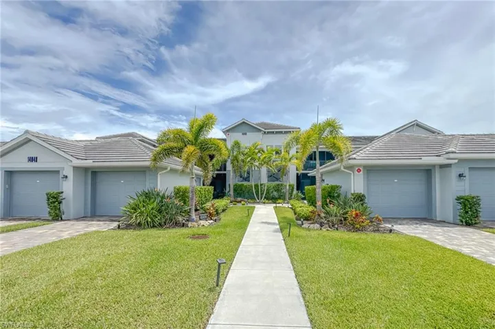 View of front of property featuring a garage, stucco siding, decorative driveway, and a front yard