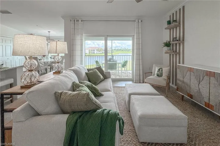 Living room with a water view, a ceiling fan, and crown molding