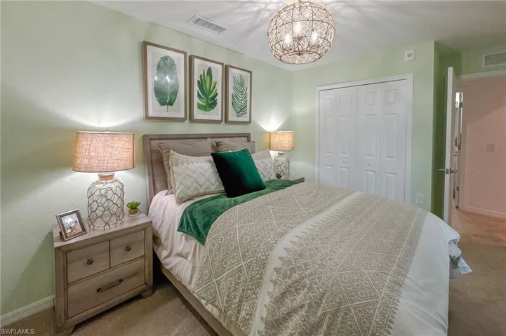 Carpeted bedroom featuring a closet and a chandelier