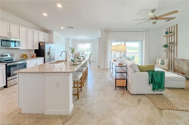 Kitchen featuring ornamental molding, appliances with stainless steel finishes, recessed lighting, a breakfast bar, and open floor plan