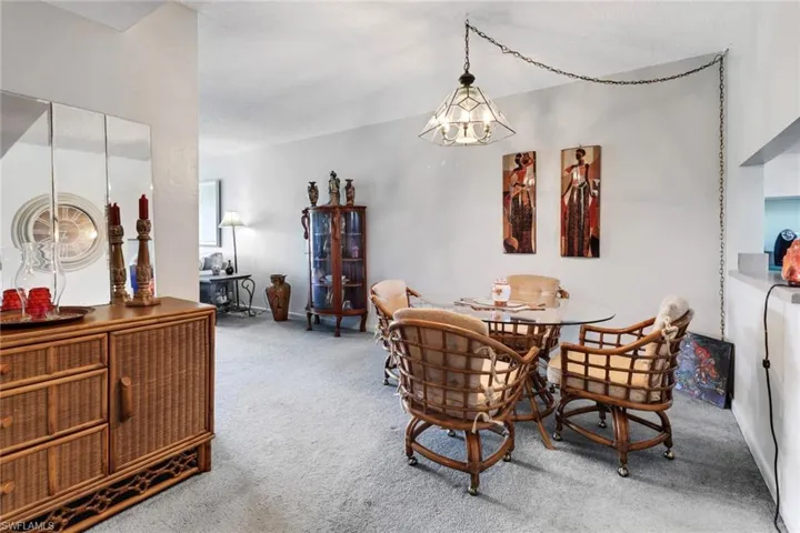 Carpeted dining area with a chandelier
