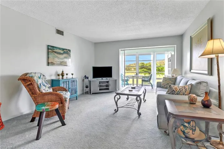 Living room featuring a textured ceiling and carpet