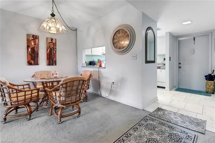 Carpeted dining space featuring a chandelier