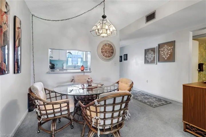 Carpeted dining space featuring a chandelier