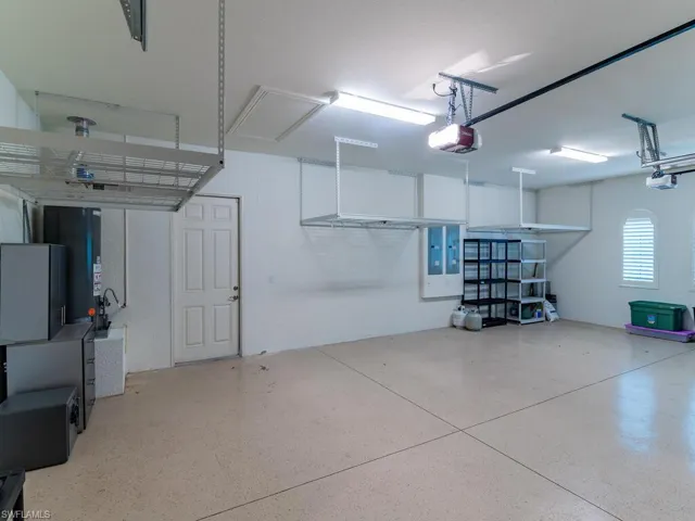 3 car garage with hanging storage and man door.