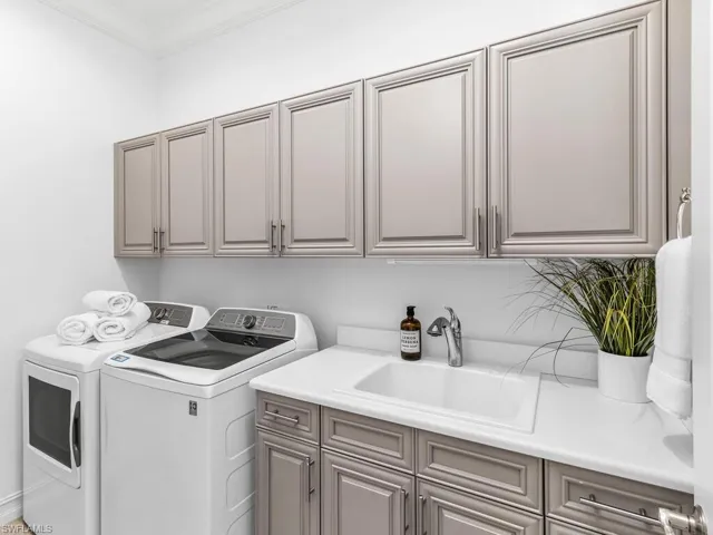 Laundry space with sink and plenty of storage.