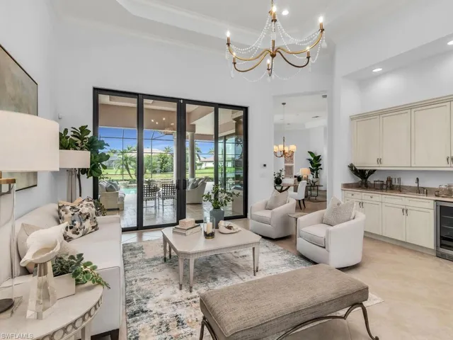 Open living room with wet bar, wine cooler, and slider access to lanai.