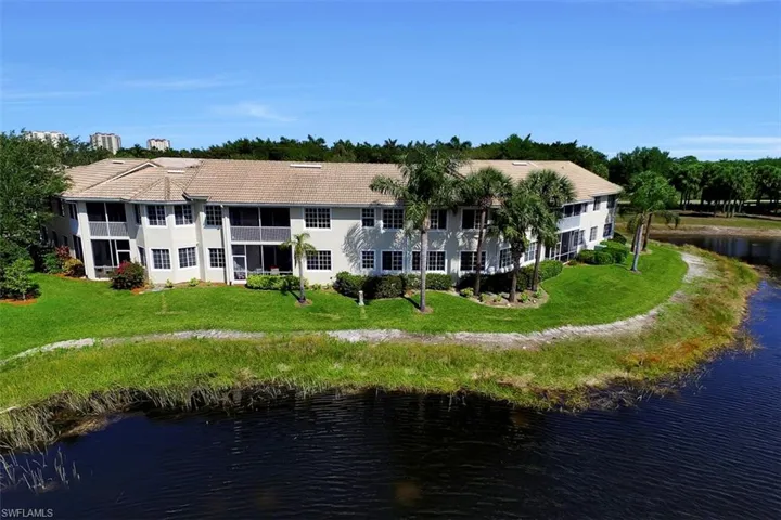 Back of house featuring a yard and a water view