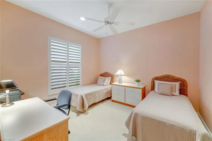 Sizable Guest Bedroom with Plantation Shutters, Recessed Lighting and two twin beds