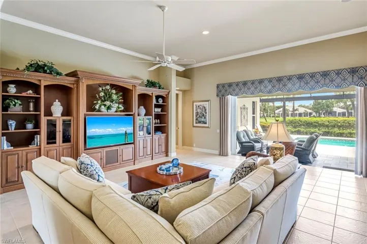 Great room with light tile patterned floors, ornamental molding, a ceiling fan, and recessed lighting