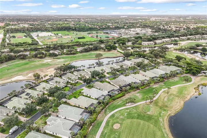 Aerial view of property's location featuring nearby suburban area, a golf club, and a large body of water