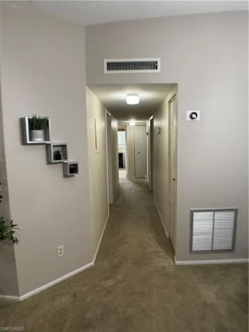 Hall featuring carpet flooring and baseboards