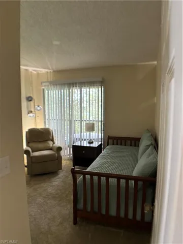 Carpeted bedroom featuring a textured ceiling