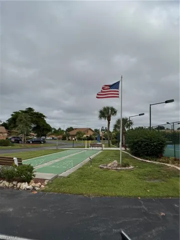 Surrounding community featuring shuffleboard and a yard