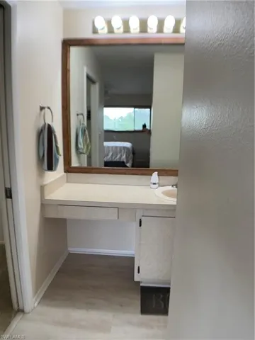 Ensuite bathroom featuring vanity and light wood-type flooring