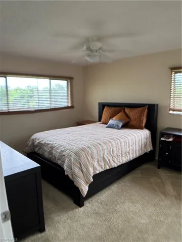Carpeted bedroom featuring a ceiling fan