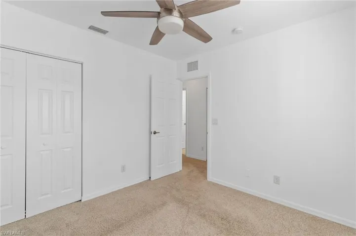 Unfurnished bedroom with carpet floors, a closet, and a ceiling fan