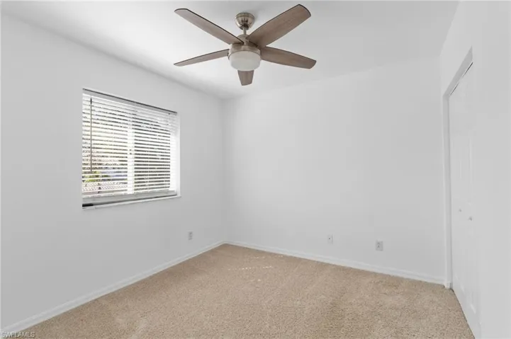 Empty room featuring carpet and ceiling fan