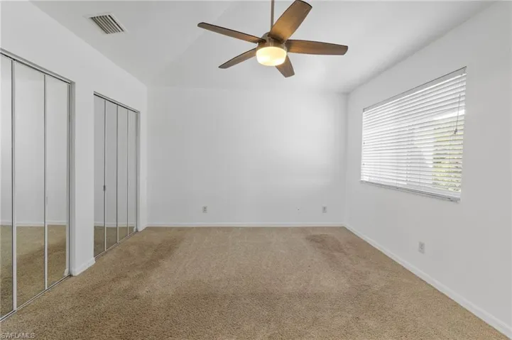 Unfurnished bedroom with multiple closets, carpet, and ceiling fan