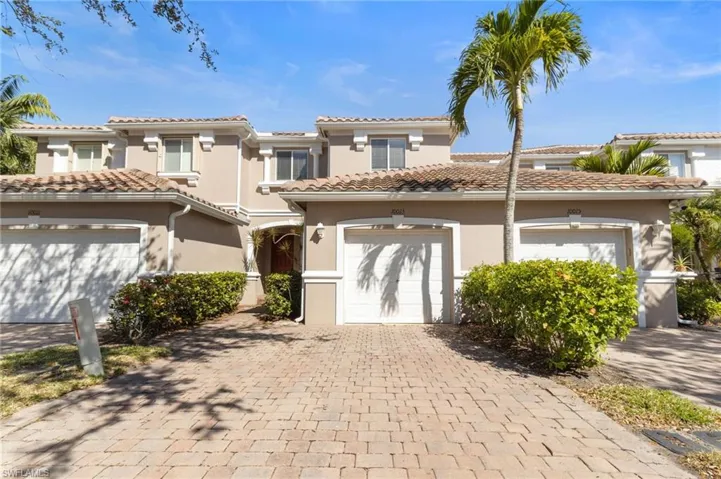 Mediterranean / spanish house with stucco siding, decorative driveway, and an attached garage