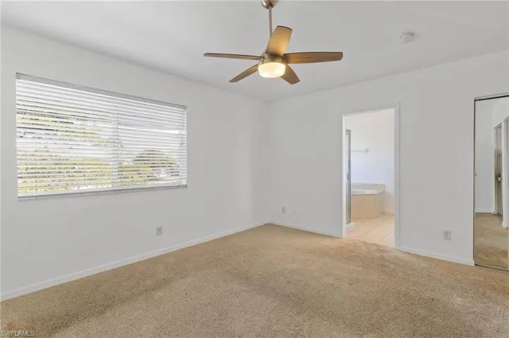 Unfurnished bedroom featuring light colored carpet and a ceiling fan