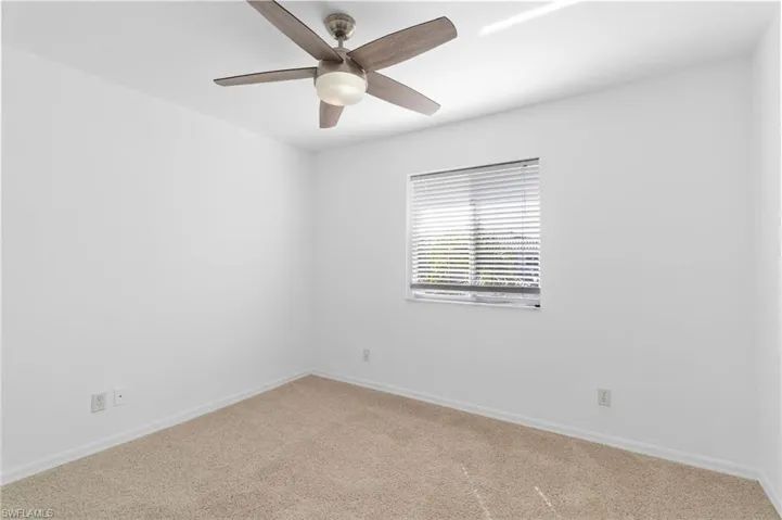 Empty room with carpet flooring and a ceiling fan