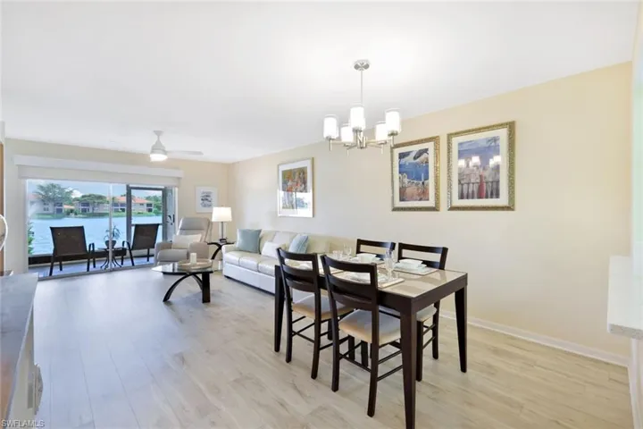 Dining area with ceiling fan with notable chandelier and light hardwood / wood-style floors