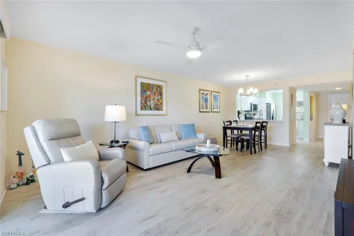 Living room featuring hardwood / wood-style flooring and ceiling fan with notable chandelier