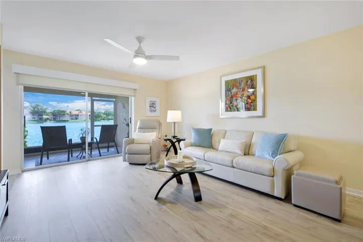 Living room featuring light hardwood / wood-style floors, ceiling fan, and a water view