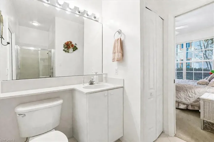 Full bath featuring vanity, a closet, ensuite bath, and a shower stall