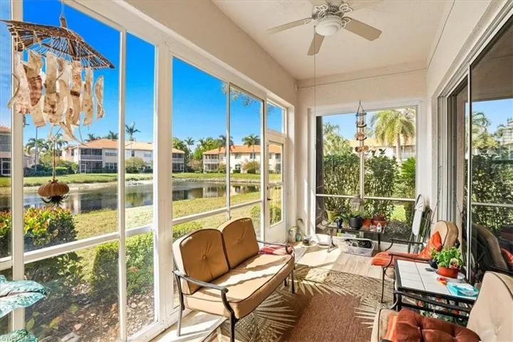Sunroom with wood finished floors and a water view