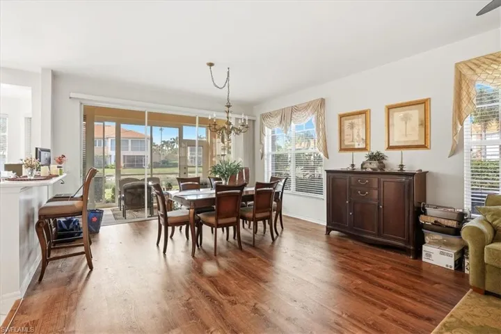 Dining space with dark wood-type flooring and hanging lights