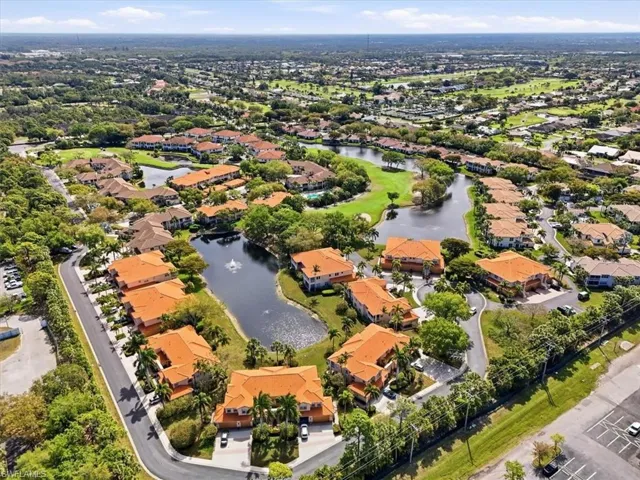Aerial view of property and surrounding area with a large body of water and nearby suburban area
