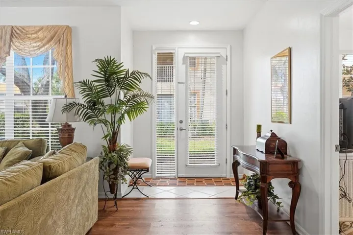 Doorway with wood finished floors and recessed lighting