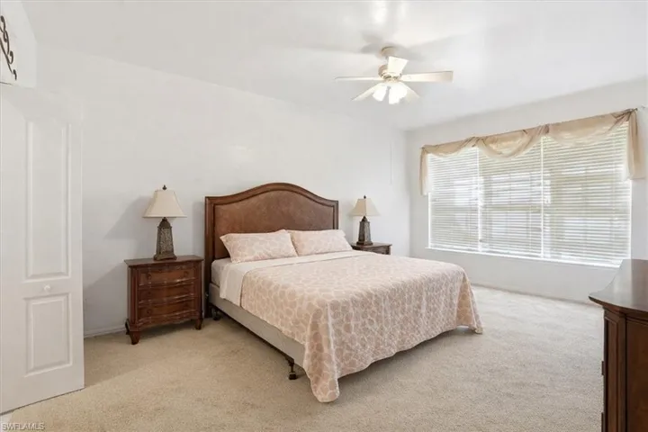 Bedroom with light carpet and ceiling fan