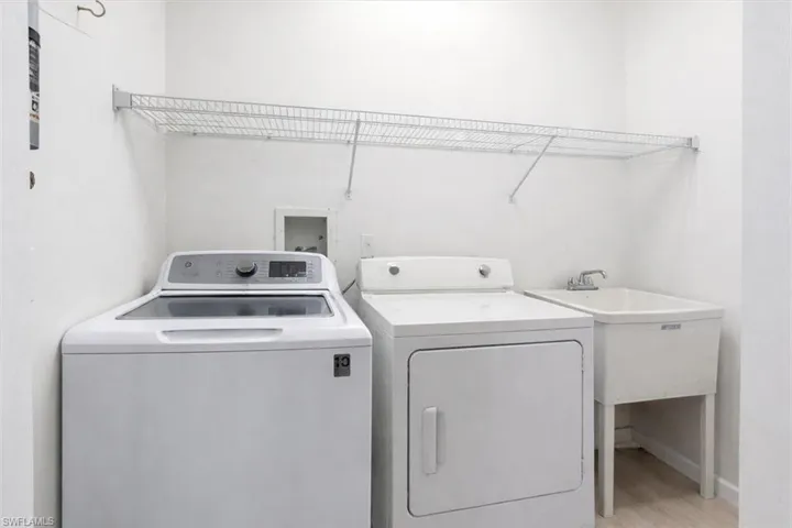 Laundry room featuring washing machine and clothes dryer and light wood-style flooring