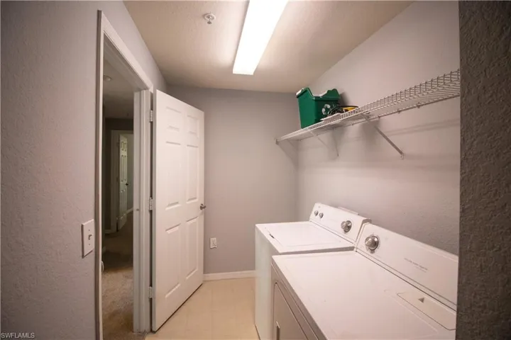 Laundry room featuring washing machine and clothes dryer and light tile patterned floors