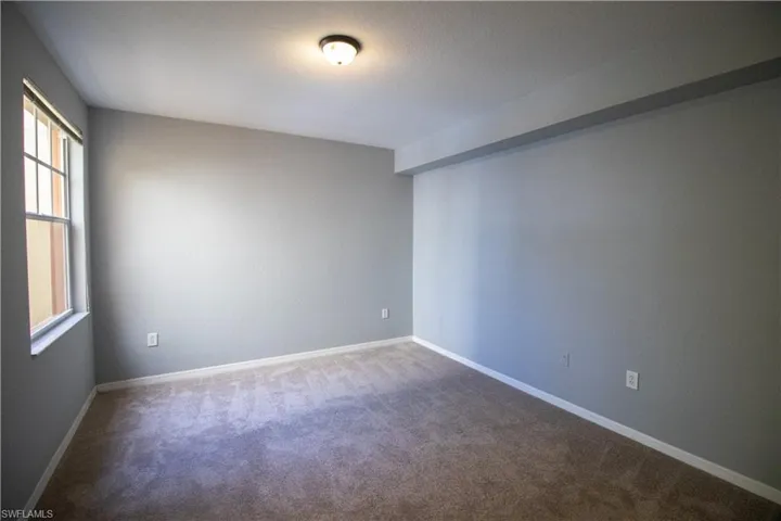 Carpeted spare room featuring a healthy amount of sunlight