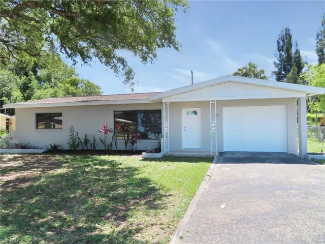 Ranch-style house with a garage and a front yard