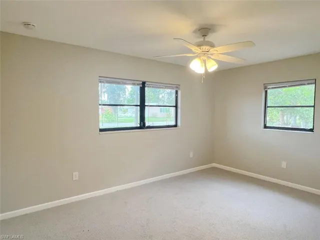 Unfurnished room featuring carpet and ceiling fan
