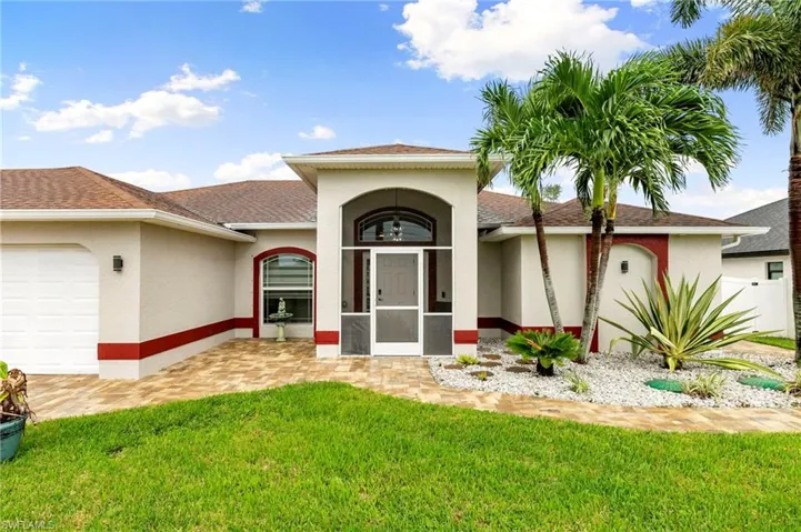 View of front facade featuring stucco siding, a front yard, an attached garage, and roof with shingles